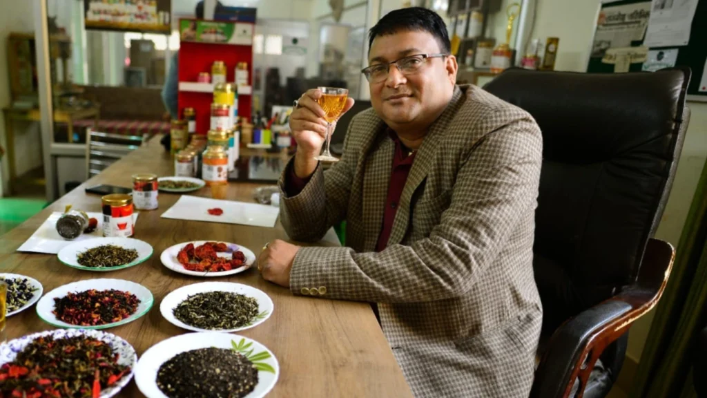 Ranjit Baruah, Founder of Aromica Tea, holding a cup of premium Assam tea while seated with specialty tea blends and wellness infusions at the company's innovation centre in Assam.